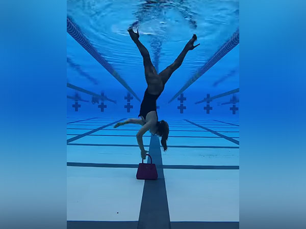 Woman walking upside down inside swimming pool
