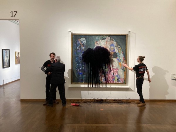 Activists throw black liquid on a painting